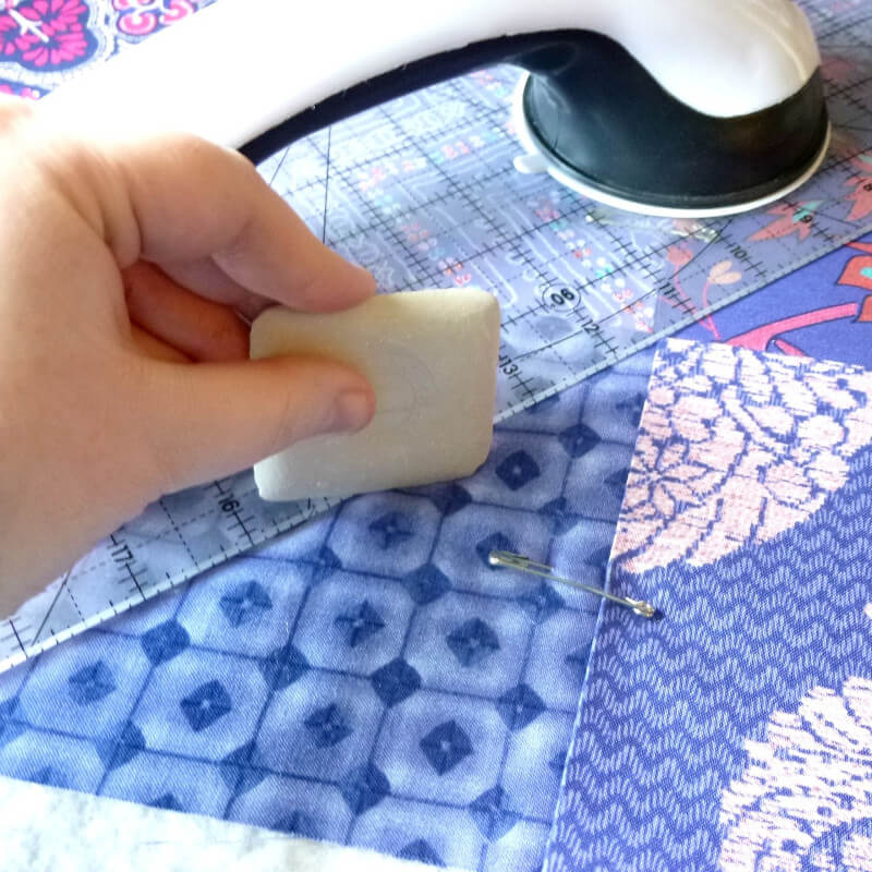 a female hand in the process of making a quilt